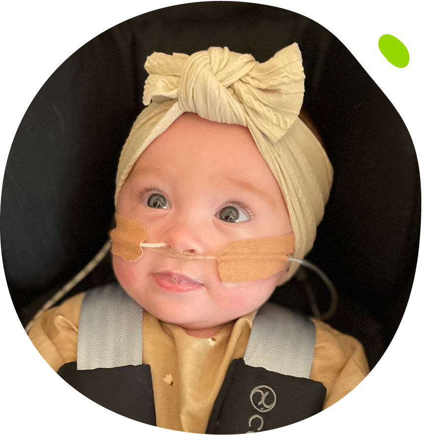 Ella's Mito Mission - Ella in car seat with bow