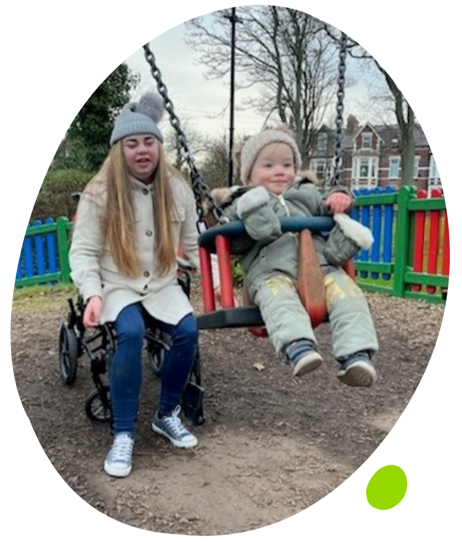 Emily on wheelchair next to swing